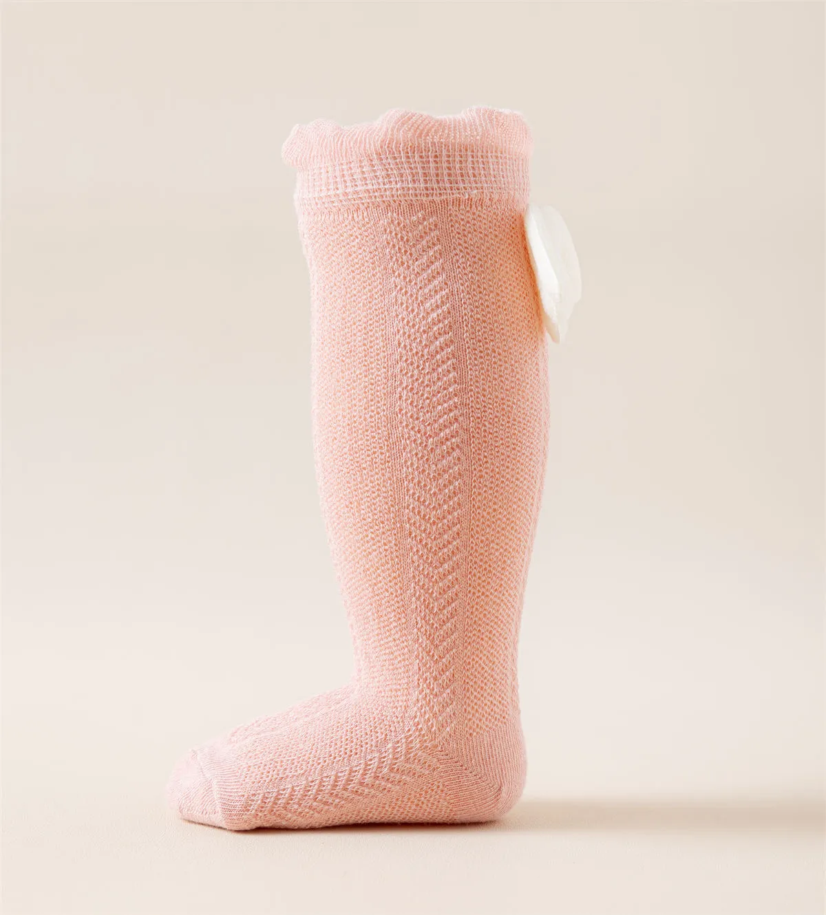 Pink baby girls knee high socks with angel wings displayed on a foot model. Pink baby girls knee high socks with angel wings displayed on a foot model.